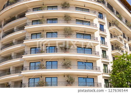 Elegant hotel facade with wrought iron balconies and potted greenery. Luxury architecture, urban landscaping, and hospitality aesthetics. Elegant hotel facade with wrought iron balconies and potted greenery. Luxury architecture, urban landscaping, and hospitality aesthetics. 127636544