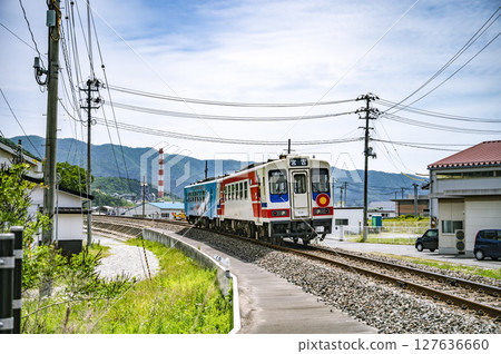 A colorful one-man train traveling through a beautiful rural town A colorful one-man train traveling through a beautiful rural town 127636660