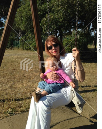 Grandmother and Granddaughter Enjoying a Swing Together 127636825
