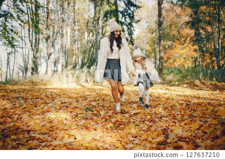 Beautiful mother with daughter. Family in a autumn park. Golden autumn 127637210