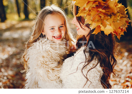Beautiful mother with daughter. Family in a autumn park. Golden autumn 127637214