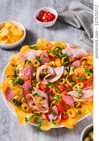 Snack trend Charcuterie nachos with potato chips on plate on table vertical view 127638512