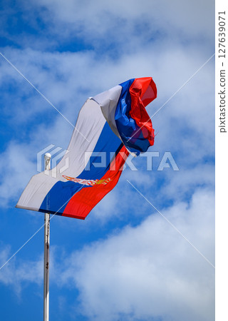Huge Flag of Serbia flapping in the wind on a flagpole Huge Flag of Serbia flapping in the wind on a flagpole 127639071