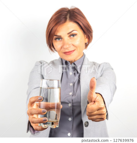 Happy beautiful business woman offers a glass of water. Thirst and health. Happy beautiful business woman offers a glass of water. Thirst and health. 127639976