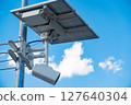 A photo of a surveillance camera with solar panels installed outdoors. 127640304