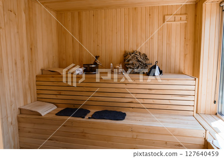 Cozy Scandinavian Sauna Interior: Natural Wood, Benches, Buckets and Towels, Relaxing Wellness Spa Scene in Warm Light, Minimalist Style. 127640459