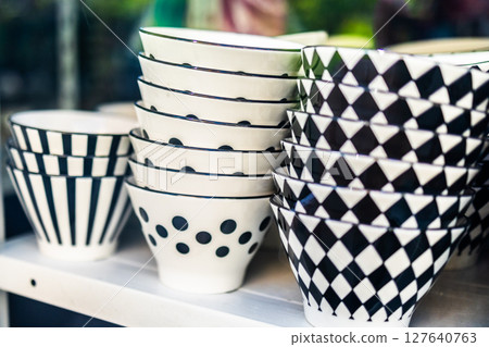 Black and white ceramic bowls with geometric patterns. Monochrome kitchen aesthetics, modern homeware, and graphic visual design. 127640763
