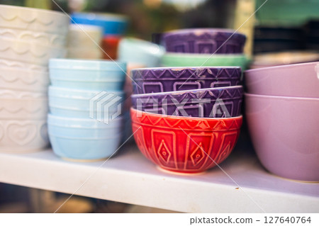Colorful patterned ceramic bowls on display. Kitchenware variety, artisanal craftsmanship, and decorative design in vibrant ceramic tableware. Colorful patterned ceramic bowls on display. Kitchenware variety, artisanal craftsmanship, and decorative design in vibrant ceramic tableware. 127640764