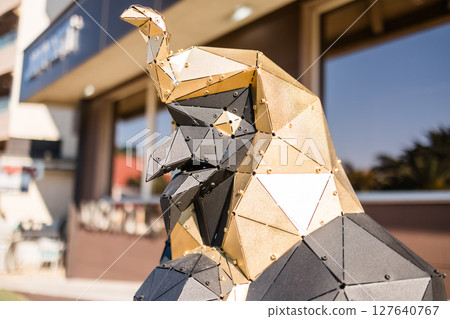 Low-poly eagle sculpture with geometric design. Urban art, modern creativity, and polygonal metal structure in a public space. Low-poly eagle sculpture with geometric design. Urban art, modern creativity, and polygonal metal structure in a public space. 127640767