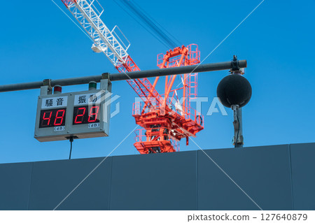 Crane and noise/vibration meter at a construction site 127640879