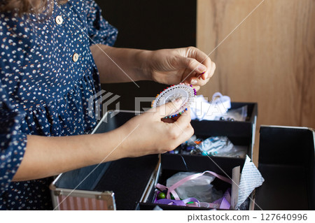 Woman Organizing Sewing Supplies at Home Craft Space 127640996