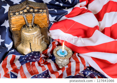 Decorated bell, candle rest on American flags, celebrating national pride during festive gathering. Decorated bell, candle rest on American flags, celebrating national pride during festive gathering. 127641066