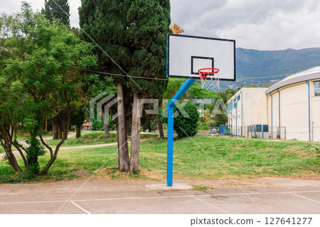 Outdoor basketball hoop in a public park. Urban recreation, sports activity, and healthy lifestyle in a community setting. 127641277