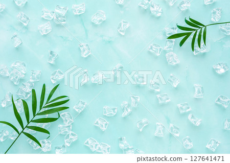 淡藍色大理石背景上的冰塊和桌棕櫚葉 淡藍色大理石背景上的冰塊和桌棕櫚葉 127641471