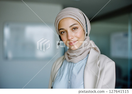A woman wearing a headset and a scarf is smiling A woman wearing a headset and a scarf is smiling 127641515