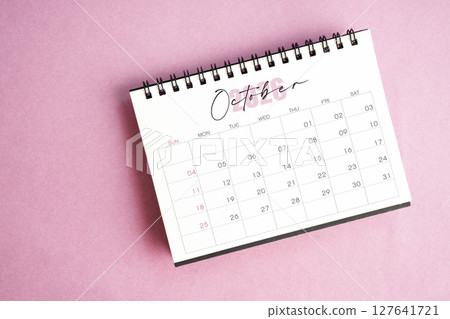 Top view of October 2026 desk calendar on pink pastel background. 127641721