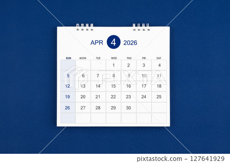 April 2026 Monthly desk calendar on navy blue color leather background. 127641929