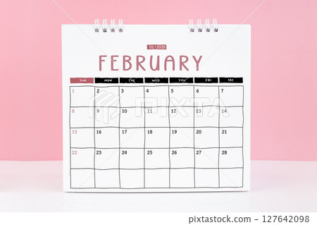 Desk calendar for February 2026 on a pink color background with copy space. Desk calendar for February 2026 on a pink color background with copy space. 127642098
