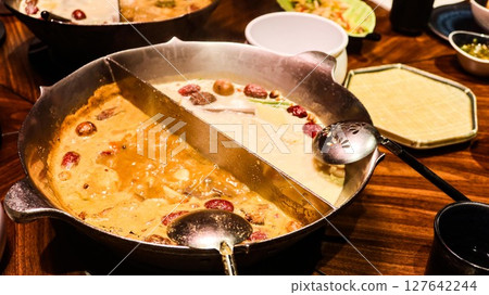 Chinese or Taiwanese hot pot with two different soup including spicy soup and a tofu (bean curd) milky soup Chinese or Taiwanese hot pot with two different soup including spicy soup and a tofu (bean curd) milky soup 127642244