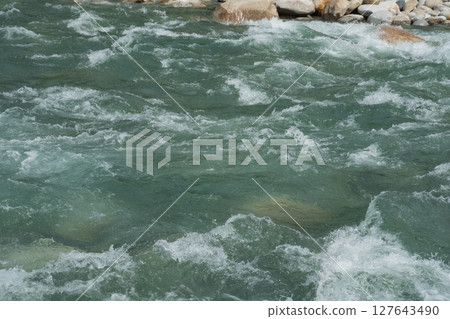 The raging torrent of a river swollen by rain (stock photo) 127643490