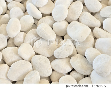 White pebbles scattered on surface create serene and natural aesthetic, perfect for landscaping or decorative purposes. Their smooth texture adds calming touch to any environment White pebbles scattered on surface create serene and natural aesthetic, perfect for landscaping or decorative purposes. Their smooth texture adds calming touch to any environment 127643970