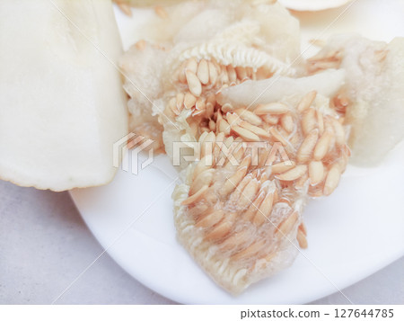 Seeds and membrane of honeydew melon on white plate Seeds and membrane of honeydew melon on white plate 127644785