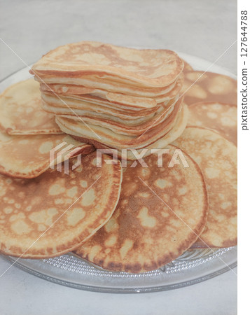 Stack of pancakes forming a delicious golden tower on a plate 127644788