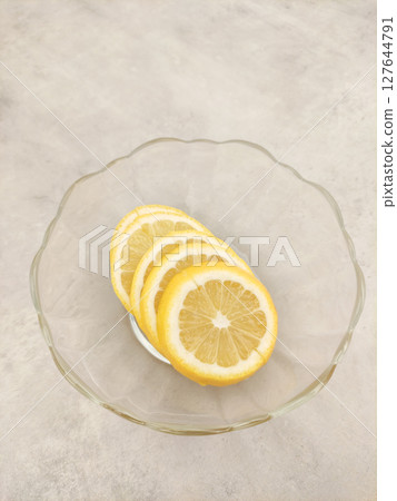 Lemon slices resting in a glass bowl on a marble countertop Lemon slices resting in a glass bowl on a marble countertop 127644791