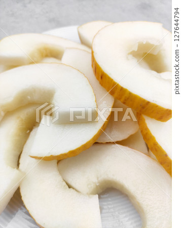 Sliced korean melon on white plate displaying refreshing pulp Sliced korean melon on white plate displaying refreshing pulp 127644794