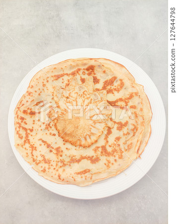Delicious homemade crepes arranged on white plate on marble table Delicious homemade crepes arranged on white plate on marble table 127644798