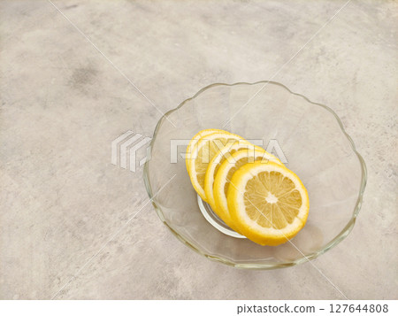 Lemon slices resting in a glass bowl on a marble countertop Lemon slices resting in a glass bowl on a marble countertop 127644808
