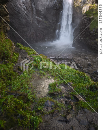 Powerful waterfall plunging through lush greenery into rocky pool, capturing autumnal landscape near aosta, italian alps in november Isollaz waterfall 127644886