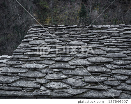 Weathered stone roof texture contrasting autumnal foliage in aosta valley, highlighting traditional mountain architectural elements pontboset Weathered stone roof texture contrasting autumnal foliage in aosta valley, highlighting traditional mountain architectural elements pontboset 127644907