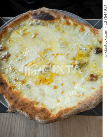 Crispy golden pizza with melted cheese, revealing authentic italian baking tradition from aosta, highlighting rustic culinary craftsmanship 127644914