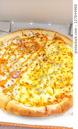 Delicious four cheese pizza with spicy sauce and red onions in cardboard box Delicious four cheese pizza with spicy sauce and red onions in cardboard box 127644966