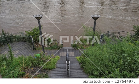 Flooded vltava river engulfing prague embankment after heavy rainfall 127644973