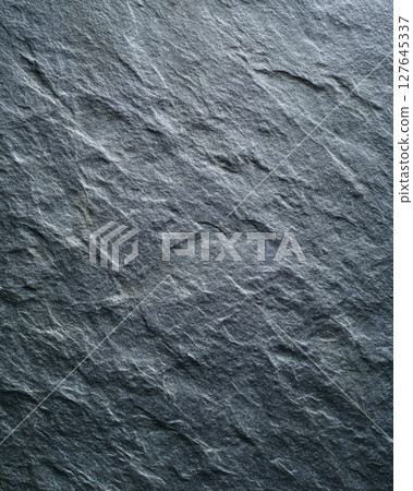 Close-up of black leathered soapstone with intersecting inlaid line details 127645337