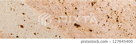 Warm beige travertine slab with natural porous texture and mineral inclusions 127645400