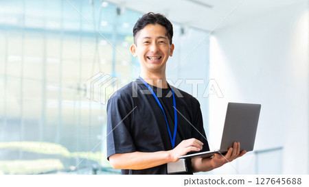 Smiling male businessman with a laptop 127645688