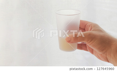 Hand with a transparent glass. 127645960
