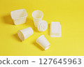 Set of disposable tableware on a yellow background. 127645963