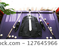 The groom's suit lies on the billiard table. 127645966