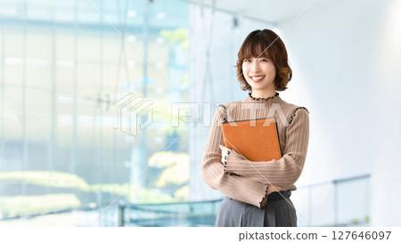 拿著活頁夾的微笑的婦女/女實業家 拿著活頁夾的微笑的婦女/女實業家 127646097