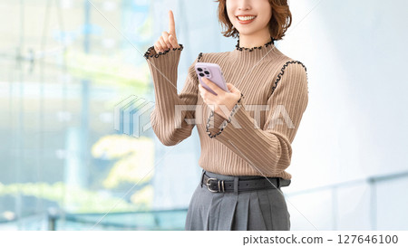 一位微笑的女人/女商人用智慧型手機指路 127646100