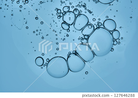 A beautiful drop of cosmetic product with bubbles on a blue background. A beautiful drop of cosmetic product with bubbles on a blue background. 127646288