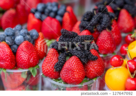 Assorted containers of berries for sale at a market. Fruits Assorted containers of berries for sale at a market. Fruits 127647092