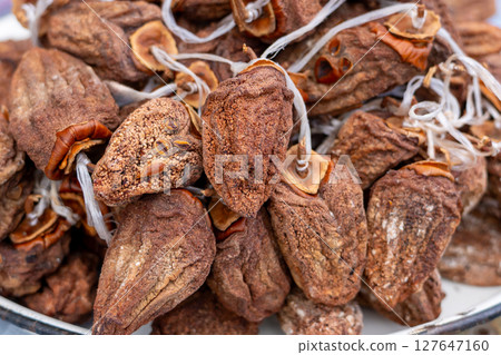 Dried persimmon fruits are sold at the market. Fruits 127647160