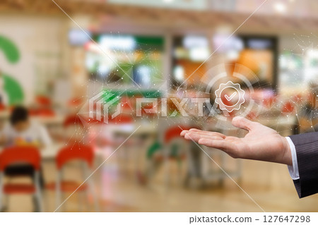 Hand holds digital checkmark in busy setting. 127647298