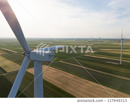 Aerial view of wind turbine on an agricultural filed at sunset. Close up of blades. Aerial view of wind turbine on an agricultural filed at sunset. Close up of blades. 127648313