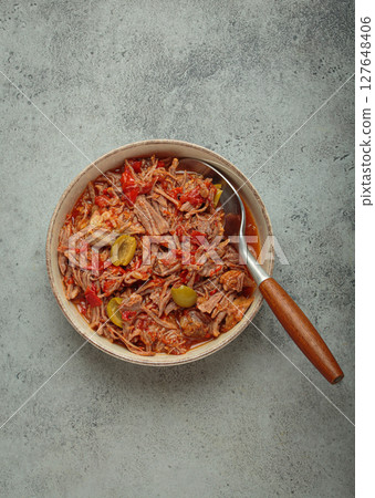 Ropa vieja with white rice, tomato sauce and green olives on a plate top view, traditional dish of Cuba Ropa vieja with white rice, tomato sauce and green olives on a plate top view, traditional dish of Cuba 127648406